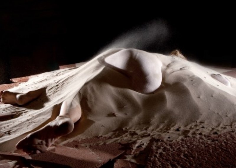 Umjetnica zatrpana pijeskom u instalaciji 'Ostaci'