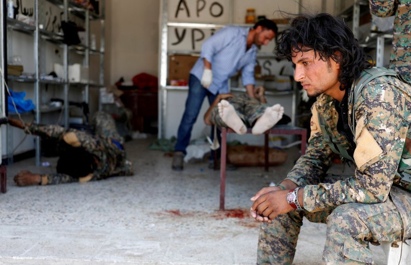 Sirijski vojnik pored ranjenog kolege u Siriji