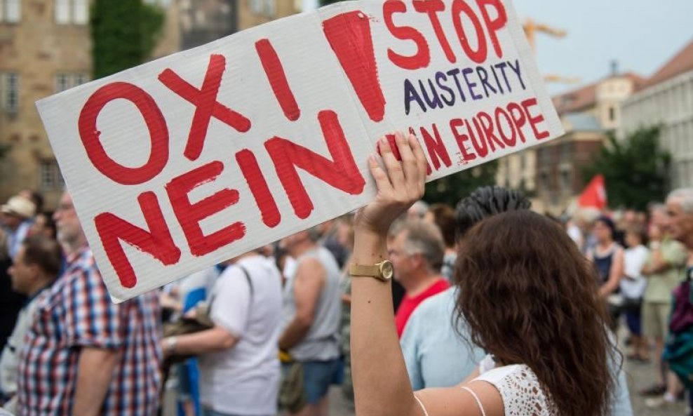 A woman holds up a sign that reads 'No!' in Greek and German and 'Stop Austerity in Europe' during a rally against the austerity measures in Greece, in?Stuttgart, Germany, 03 July 2015. The 'Neue hellenische Gemeinde Stuttgart' (lit. New Hellenic Communit