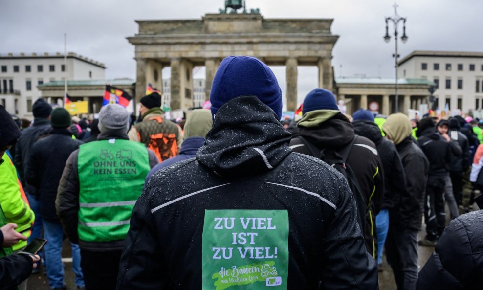 'Što je previše, previše je', piše na leđima poljoprivrednika koji prosvjeduje protiv mjera štednje njemačke vlade u Berlinu