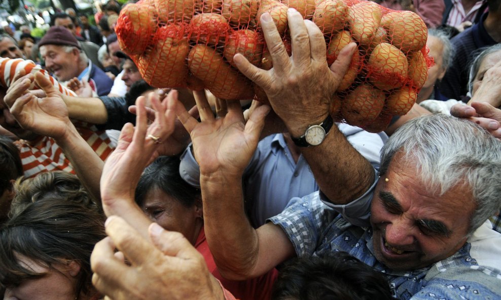 A man grabs a bag of potatoes before distribution to citizens in front of the Constitutional Court in central Sarajevo September 25, 2009, during a protest against the lack of legislation to protect a market quota for domestic agricultural produce. Bosnia