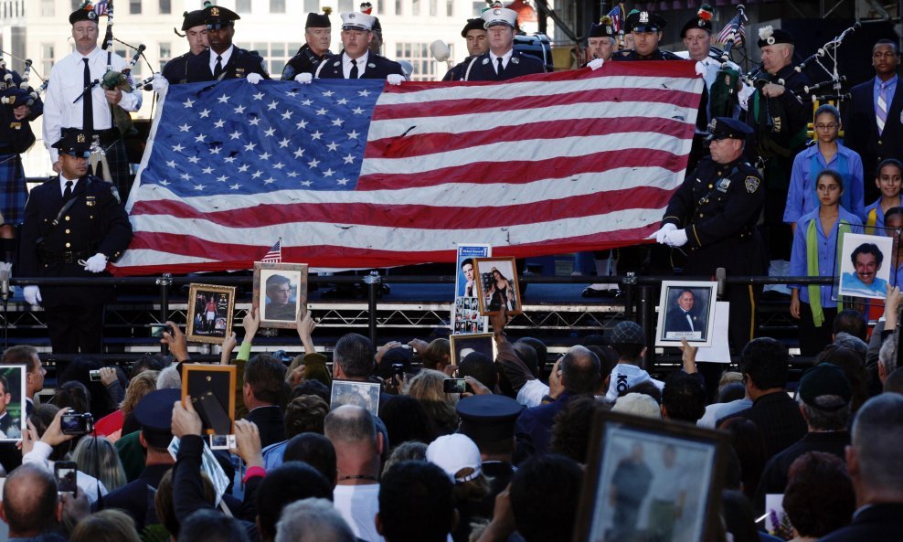 Njujorški vatrogasci drže zastavu tijekom komemoracije na Ground Zero
