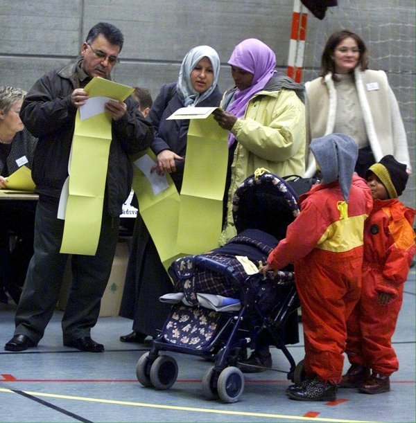 Imigranti s djecom proučavaju glasački listić na parlamentarnim izborima u Danskoj