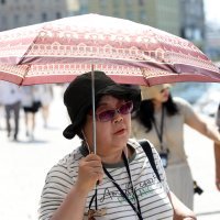 Turisti se u Šibeniku od jakog sunca štite kišobranima
