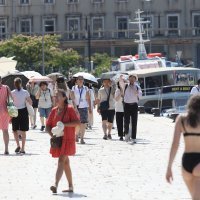 Turisti se u Šibeniku od jakog sunca štite kišobranima