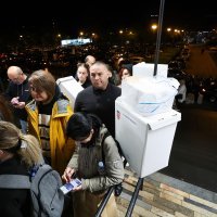 Red ispred Državnog izbornog povjerenstva, ljudi stoje s kutijama biračkih listića