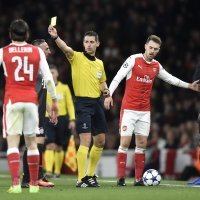 Arsenal v Bayern Munich - Sudac  Anastasios Sidiropoulos pokazuje žuti karton Theo Walcottu