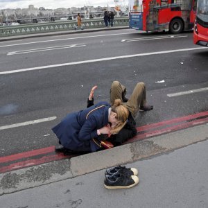 Žena pomaže ranjenima u napadu kod mosta Westminister u Londonu