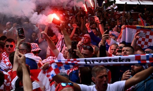Hrvatski navijači u korteu s najvećom zastavom na stadionu; skandira se Modriću