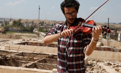 Irački violinist svira dok pucnjava i eksplozije odjekuju Mosulom