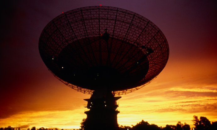 Parkes radio telescope. View of Parkes radio telescope, New South Wales, Australia at sunset. The rotating dish is 64 metres in diameter and divided into three sections. It has a solid steel plate from its centre to a diameter of 17 metres, a perforated a