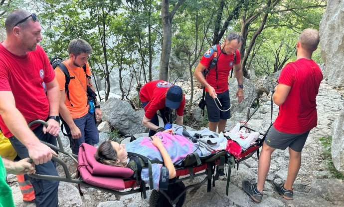 Pripadnici HGSS-a prenose novopečenu majku do tima Hitne pomoći