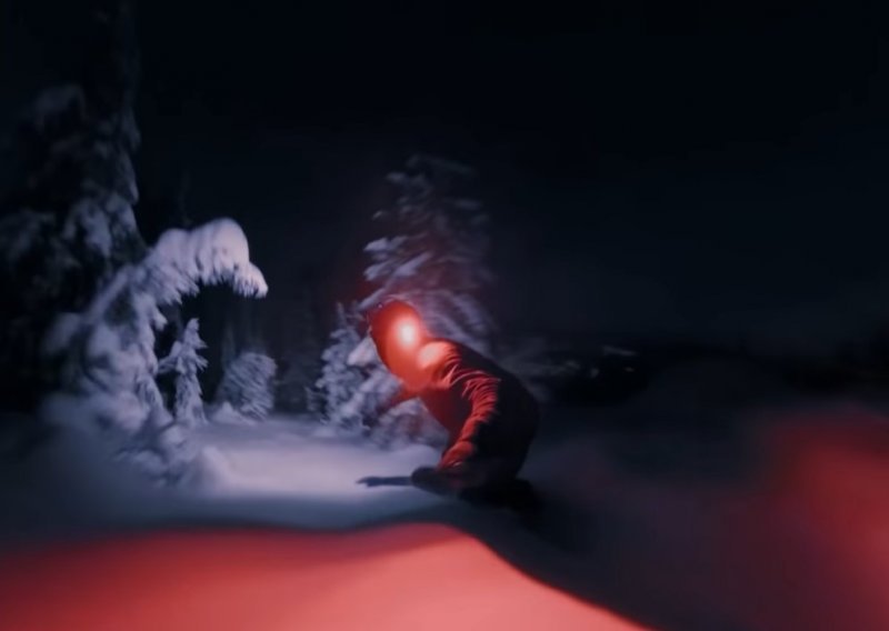 Vješti snowboarder spustio se niz brijeg po mraku