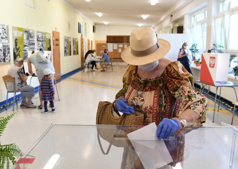 Redovi i restriktivne mjere na predsjedničkim izborima u Poljskoj; svatko nosi svoju kemijsku olovku, imaju maske, rukavice...