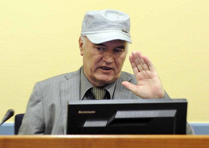 Mladic shows pictures of deceased family members in court