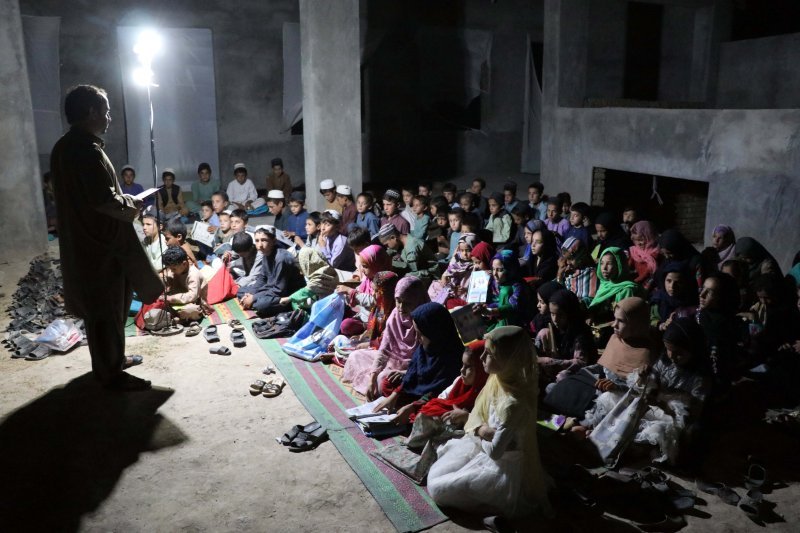 Abdul Nafe Aftab podučava učenike u objektu na otvorenom u jednom selu u provinciji Kandahar u Afganistan. Aftab je preuzeo na sebe zadatak da podučava djecu u pokušaju da iskorijeni nepismenost u tom području zbog nedostatka škola.