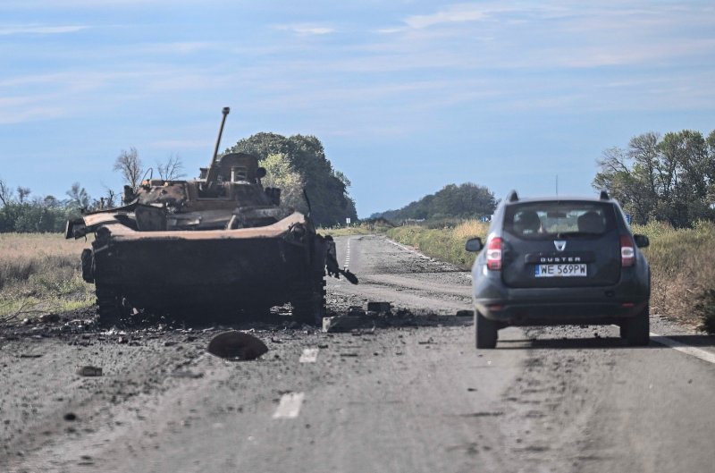 Automobil prolazi pored uništenog oklopnog vozila u Balakliji, u ukrajinskoj regiji Harkiv, 10. rujna 2022.