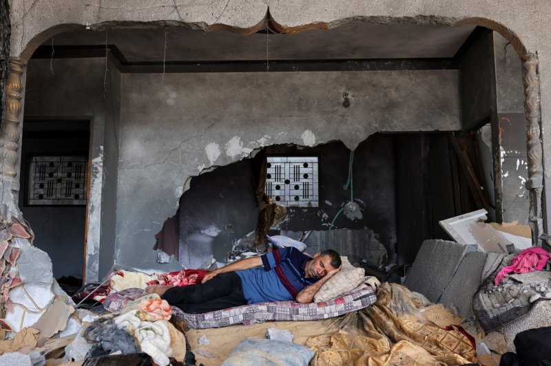 Palestinac spava u svojoj teško oštećenoj kući