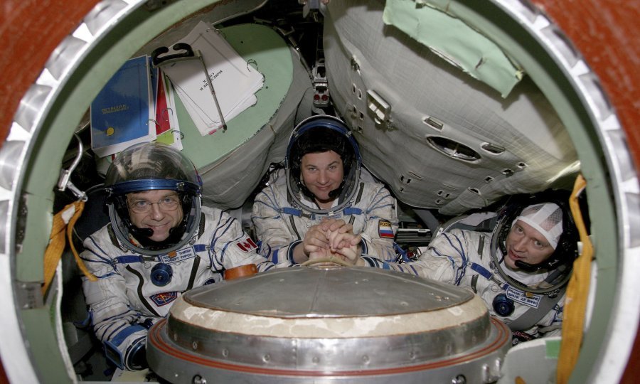 Kanadski astronaut Robert Thirsk, ruski kozmonaut Roman Romanenko i astronaut Europske svemirske agencije (ESA), Belgijanac Frank De Winne, poziraju u svemirskoj kapsuli u centru Star City nadomak Moskve. Foto: Sergei Remezov/REUTERS