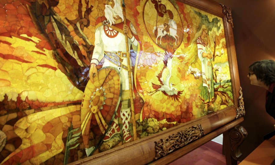 A woman looks at a mosaic panel at the jewellery exhibition Junwex in St. Petersburg February 6, 2009. The panel that measures 2.2 m by 1.2 m and is made of almost 3,000 pieces of amber is the largest of its kind in the world, its creator Alexander Zhurav