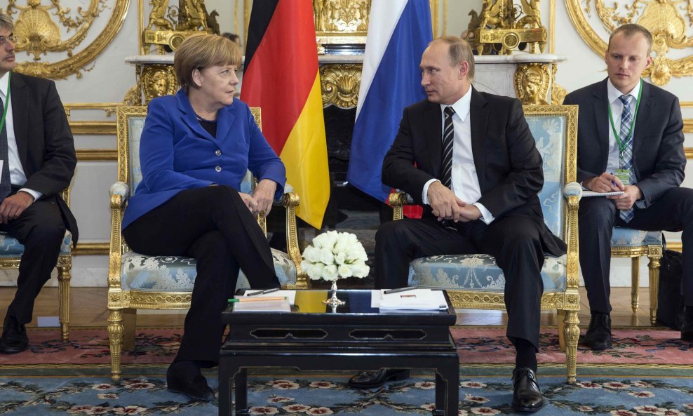 German Chancellor Angela Merkel (L) sits with Russian President Vladimir Putin during a bilateral meeting prior to a summit on Ukraine at the Elysee Palace in Paris, France, October 2, 2015. France hosts a meeting with leaders of Russia, Germany and Ukrai