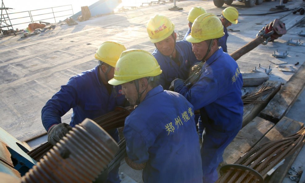 Radnici podižu posljednji komplet kabela na gradilištu visećeg mosta preko Jangcea u Nantongu 15. studenoga 2019.