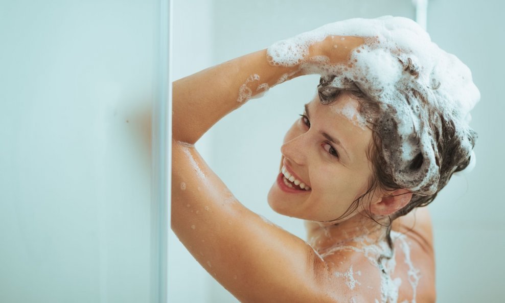 žena pere kose šamponiranje