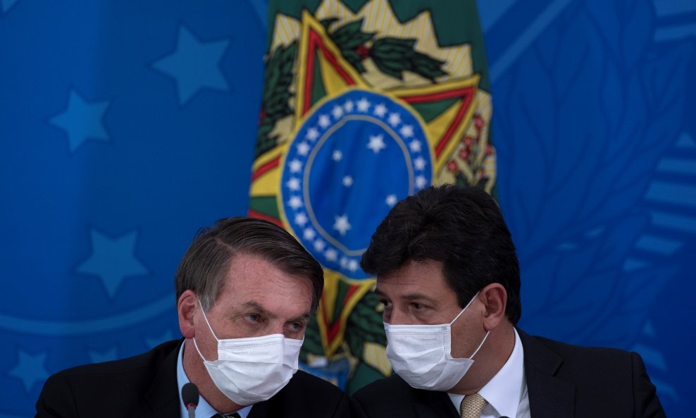 Predsjednik Brazila Jair Bolsonaro (lijevo) i sad već bivši ministar zdravstva Luiz Henrique Mandetta (desno)