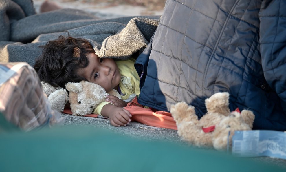 Dijete spava na cesti nakon požara u kampu Moria