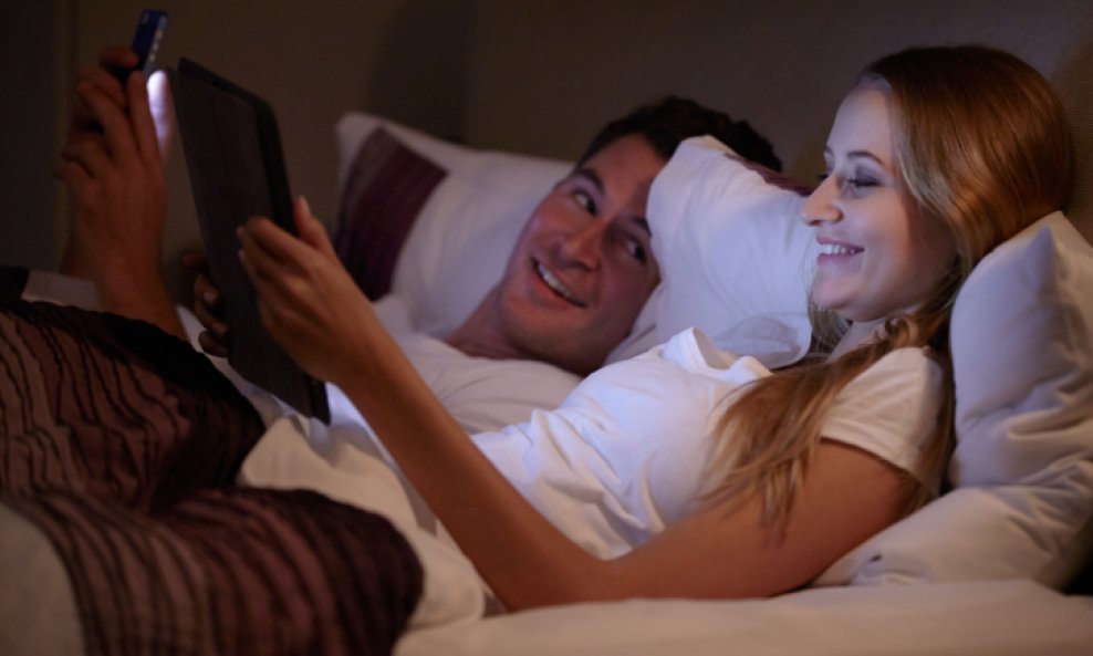 muškarac žena par krevet gadgeti smartphoe tablet pametni telefon