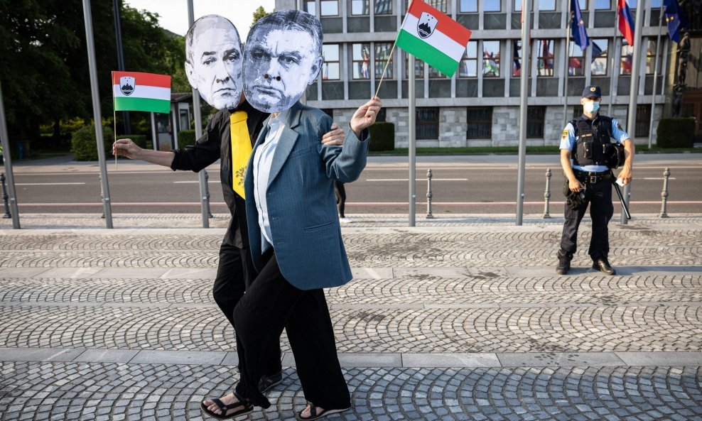 Prosvjednici u Ljubljani 18. lipnja u maskama s licima slovenskog premijera Janeza Janše i mađarskog premijera Viktora Orbana