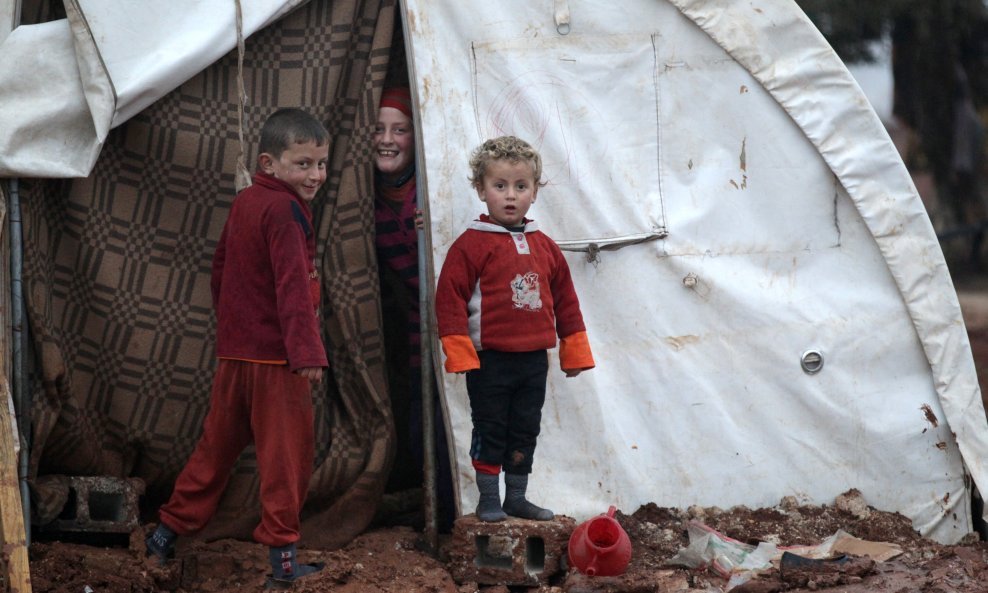 Internally displaced Syrian children stand at their tent in the Bab Al-Salam refugee camp, near the Syrian-Turkish border, northern Aleppo province, Syria December 26, 2016. REUTERS/Khalil Ashawi