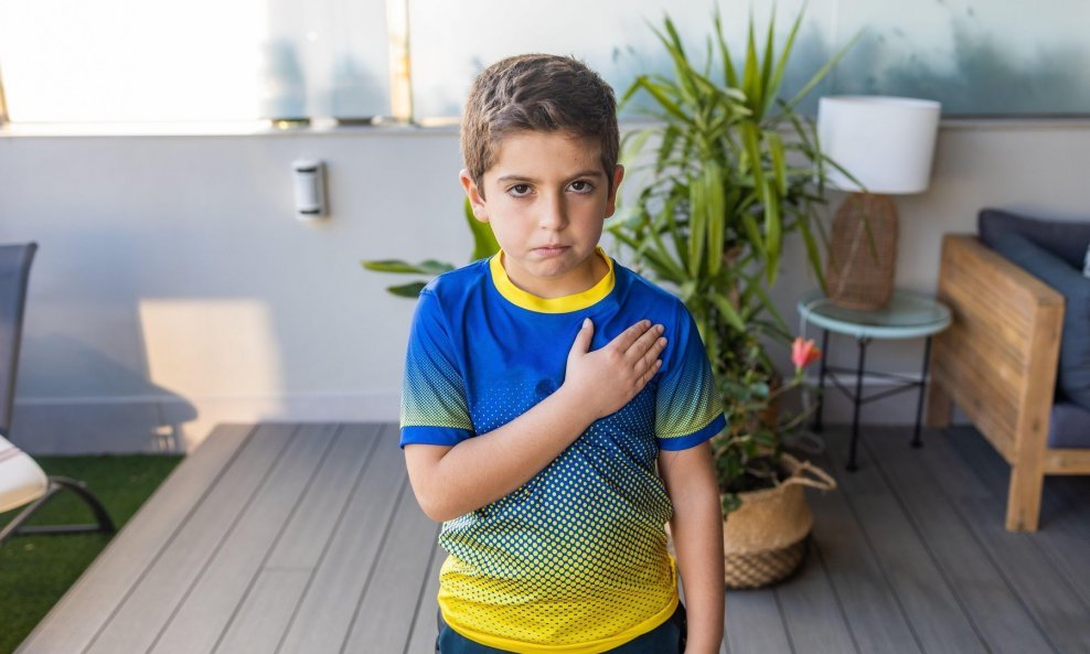 Dječak s majicom Ukrajine moli se za svoju zemlju