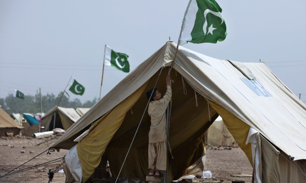 Dječak Nasir (11) iz doline Swat, čija je obitelj prije nekoliko mjeseci izbjegla zbog rata protiv Talibana u toj regiji, stavlja pakistansku zastavu na šator u UNHCR-ovom kampu Jalozai u predgrađu Peshawara, oko 140 kilometara sjeverozapadno od Islamabad