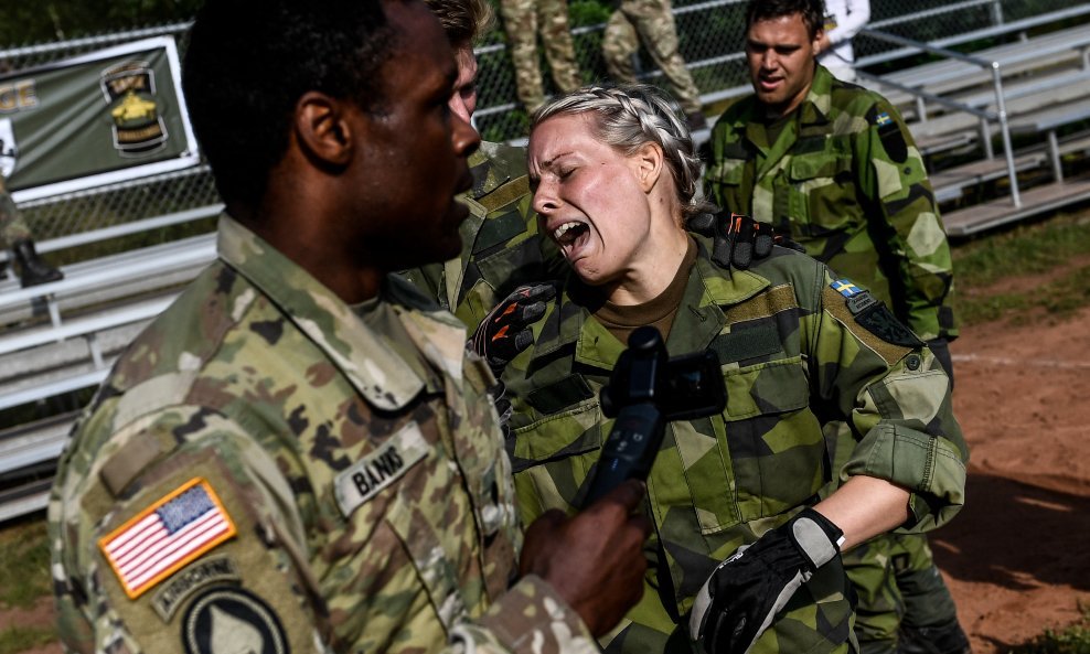 Pripadnica švedske vojske okružena američkim vojnicima nakon napornog treninga na pogonu za obuku NATO-a u njemačkom Grafenwoehru