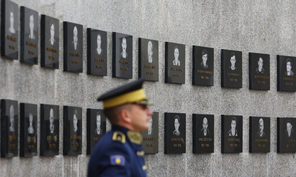 Član kosovskih obrambenih snaga stoji kod spomenika ubijenim kosovskim Albancima u selu Račak 1999.