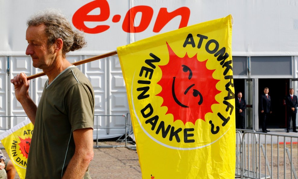 An anti-nuclear power activist carries a flag "Nuclear Power - No Thanks" outside the annual general shareholders meeting of E.ON SE Climate and Renewables in Essen, Germany, June 8, 2016.