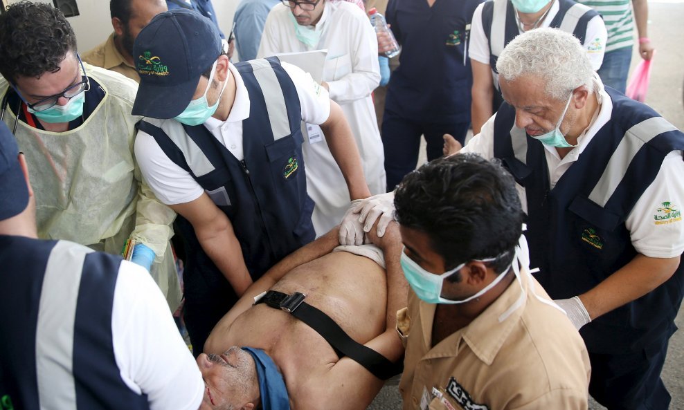 Medical staff carry a way wounded pilgrim following a crush caused by large numbers of people pushing at Mina, outside the Muslim holy city of Mecca September 24, 2015. The death toll from a stampede during the annual Muslim hajj pilgrimage in Saudi Arabi
