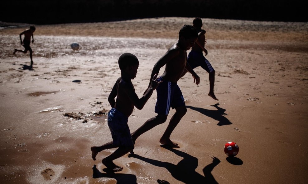 Djeca igraju nogomet na plaži u Salvadoru, jednom od gradova domaćina SP u Brazilu