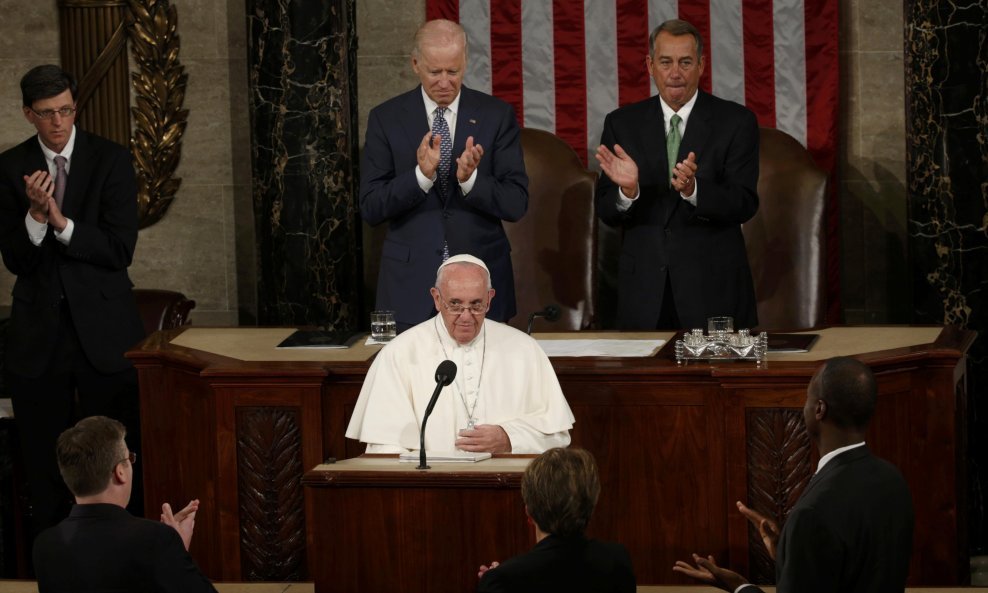 Pope Francis pauses after concluding his addresses before a joint meeting of the U.S. Congress as Vice President Joe Biden (L) and Speaker of the House John Boehner (R) applaud in the House of Representatives Chamber on Capitol Hill in Washington Septembe