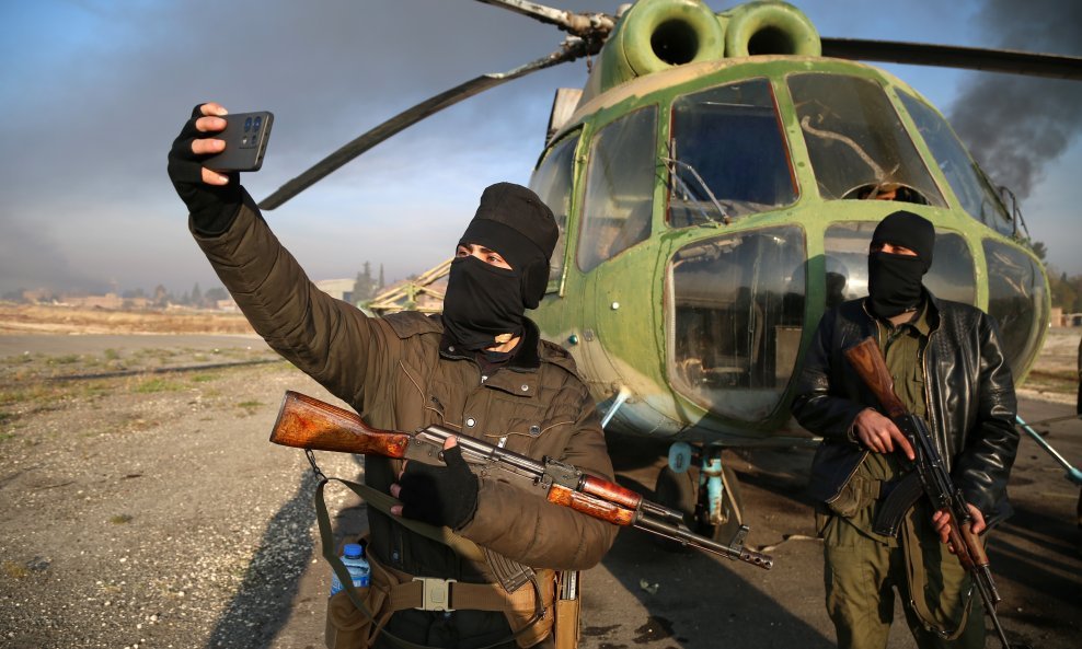 Pripadnici sirijskih pobunjenika rade 'selfie' ispred helikoptera na vojnom aerodromu kod Alepa kojeg su zauzeli proteklih dana