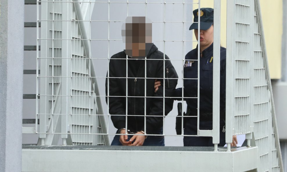 U zgradu ga je uvela policajka s lisicama na rukama