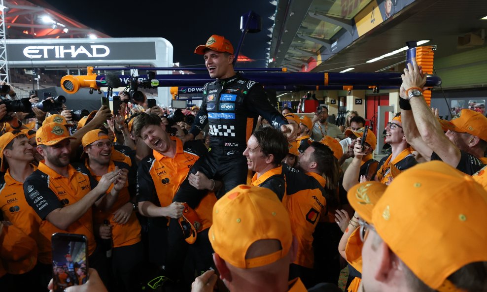 Lando Norris na rukama članova ekipe