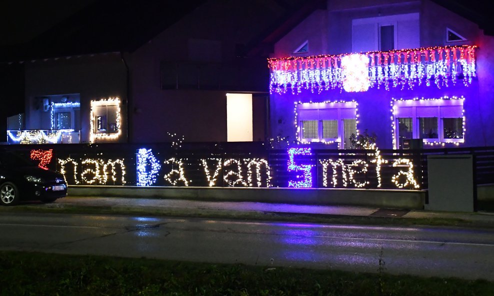 Na ogradi i pročelju kuće lampicama ispisao 'Znam da vam smeta'