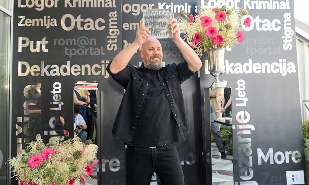 Boris Dežulović, laureat tportalove nagrade, sa skulpturom Silvija Vujičića