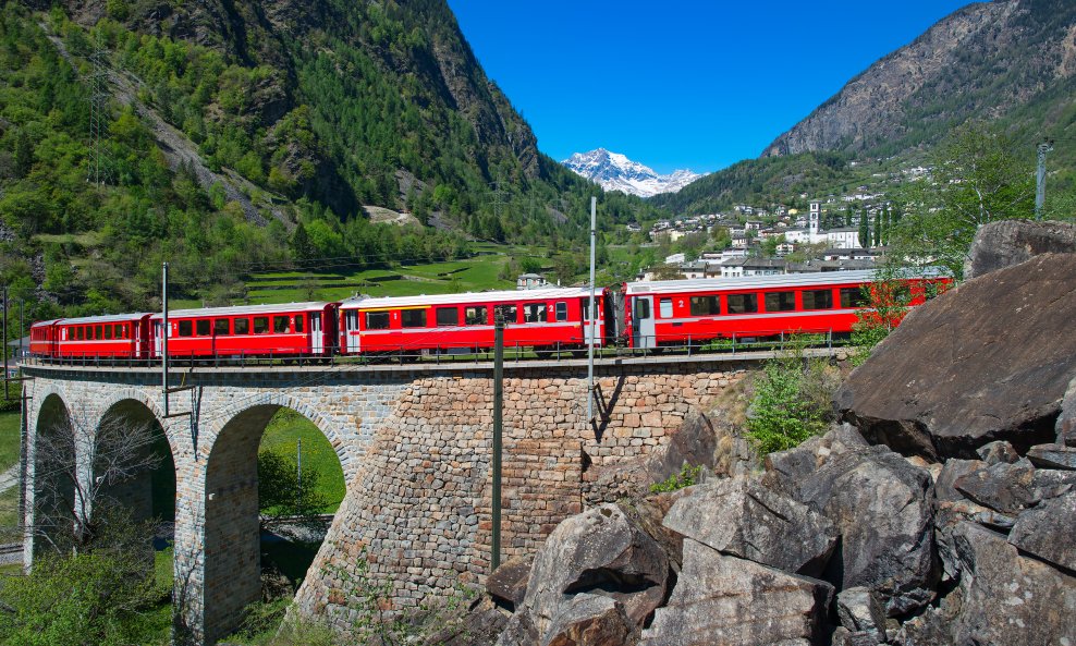 Jarkocrveni Bernina Express vijuga preko legendarnog vijadukta Brusio na putu prema talijanskom Tiranu