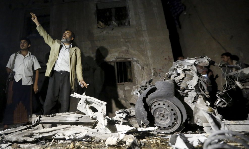 A man reacts as he stands next to wreckage at the site of a car bomb attack outside his house in Yemen's capital Sanaa June 29, 2015. A car bomb claimed by Islamic State exploded in the Yemeni capital Sanaa overnight, medics said, wounding at least 28 peo