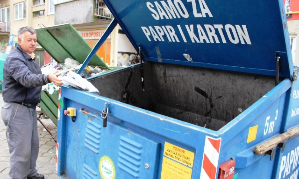 Kontejner za papir  u središtu grada prazan, a do njega  kontejner za komunalni otpad pun papira