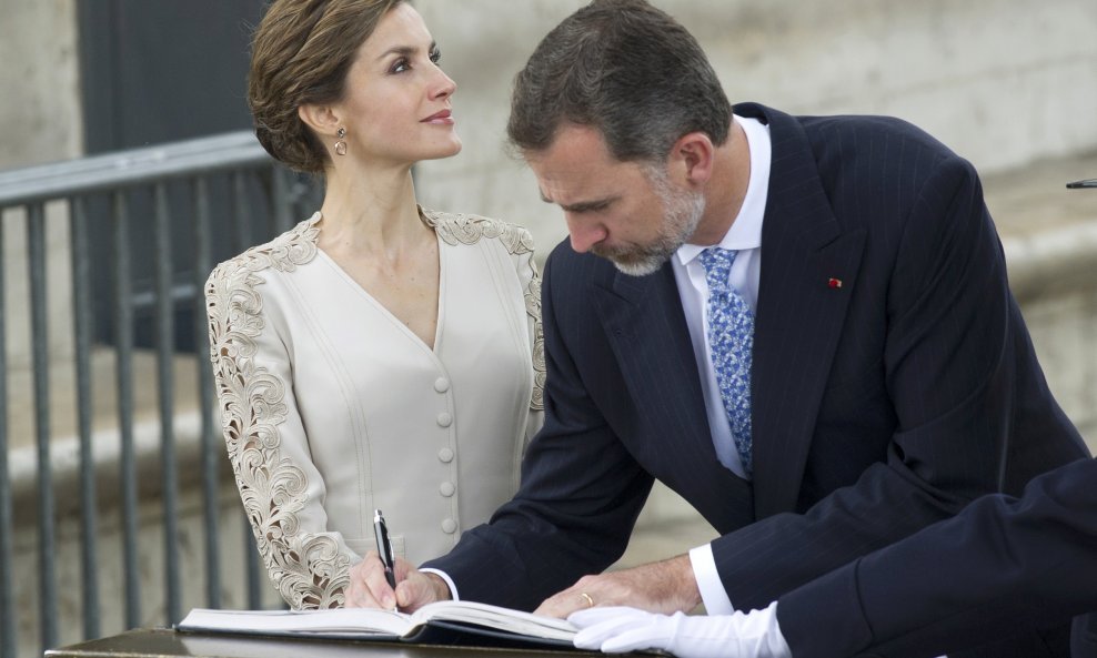 Spain's King Felipe VI (R) and Queen Letizia sign the official guest book as they attend a wreath laying ceremony at the Arc de Triomphe in Paris, France, June 2, 2015. The King and Queen of Spain resume their state visit to France which was interrupted o