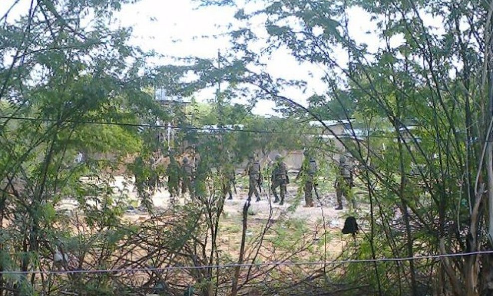 Kenya Defence Forces soldiers move behind a thicket in Garissa town in this photograph taken from a mobile phone April 2, 2015. Masked gunmen stormed the campus at Garissa University College in northeastern Kenya on Thursday, setting off explosions and ex